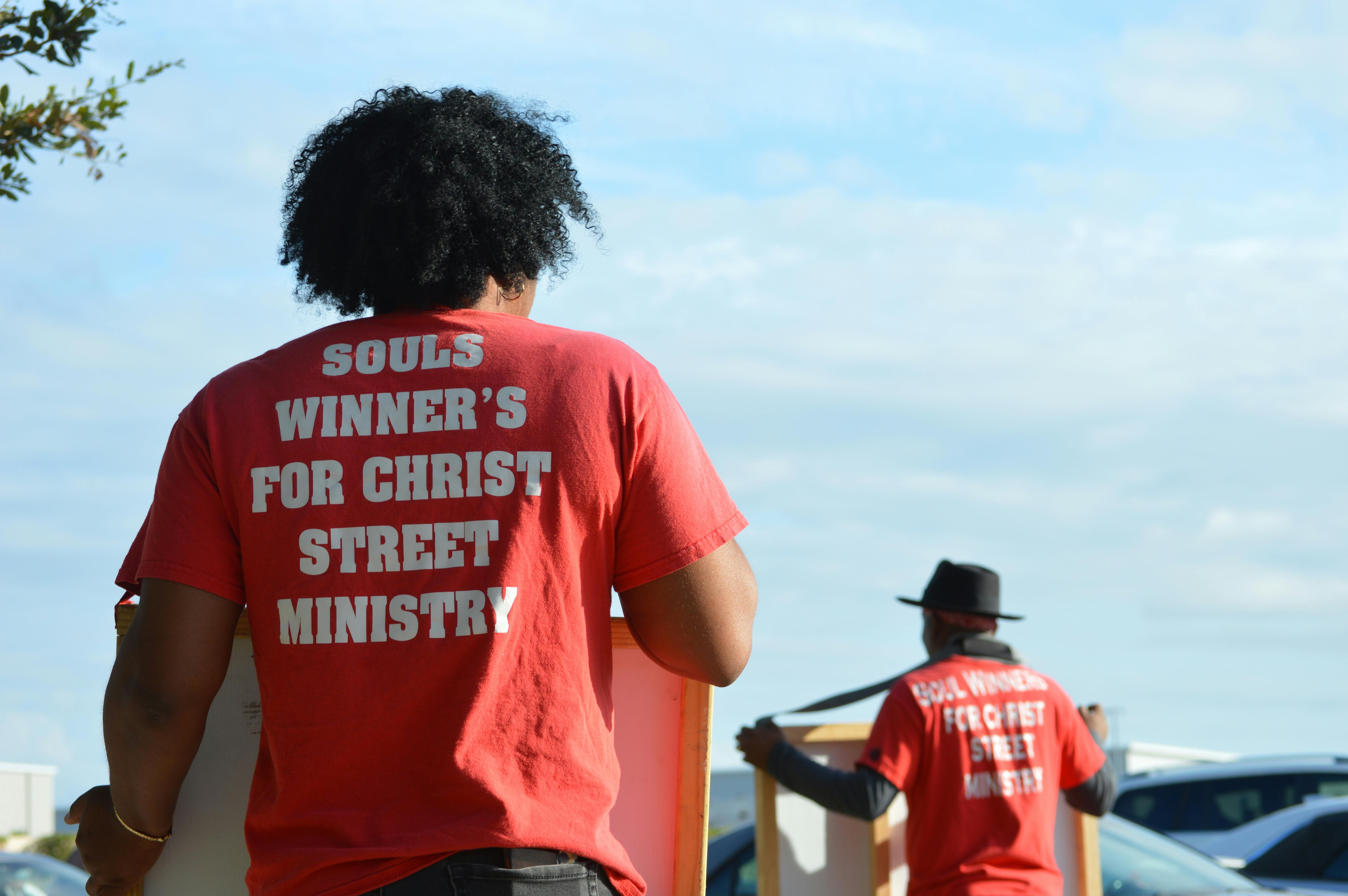 Volunteers from street ministry engaging with community outdoors, spreading positive messages.