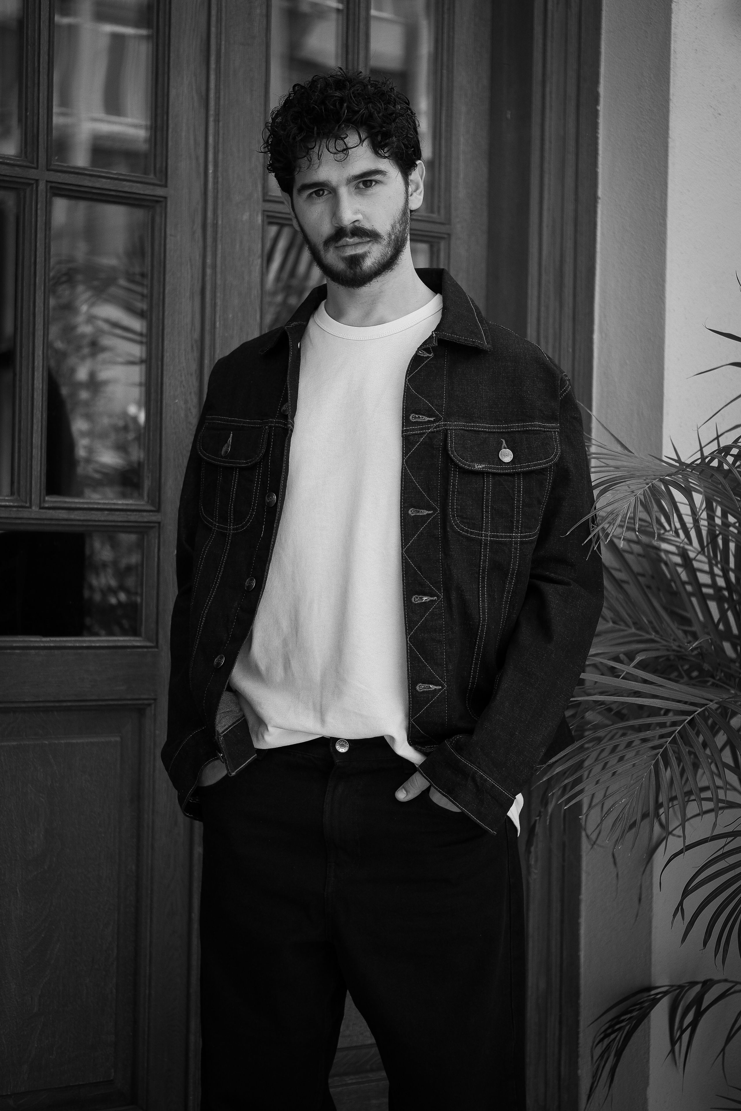 Black and white portrait of a man in a denim jacket.