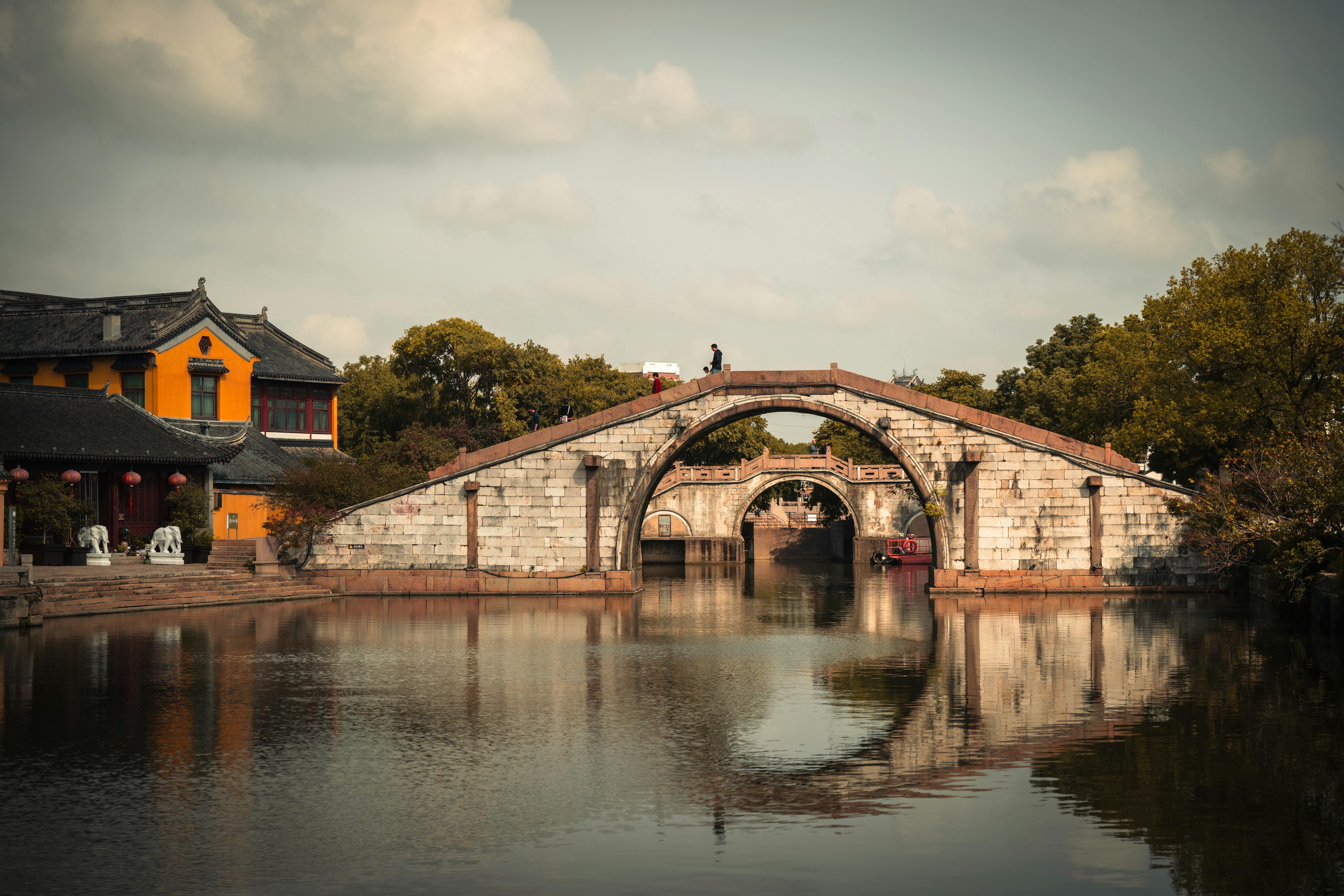 Zhujiajiao Water Town ancient stone bridge over canal with traditional Ming dynasty houses at golden hour