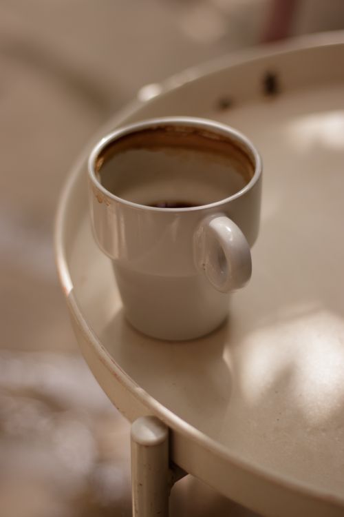 Free A warm coffee cup sits on a table, capturing a cozy and serene café ambiance. Stock Photo