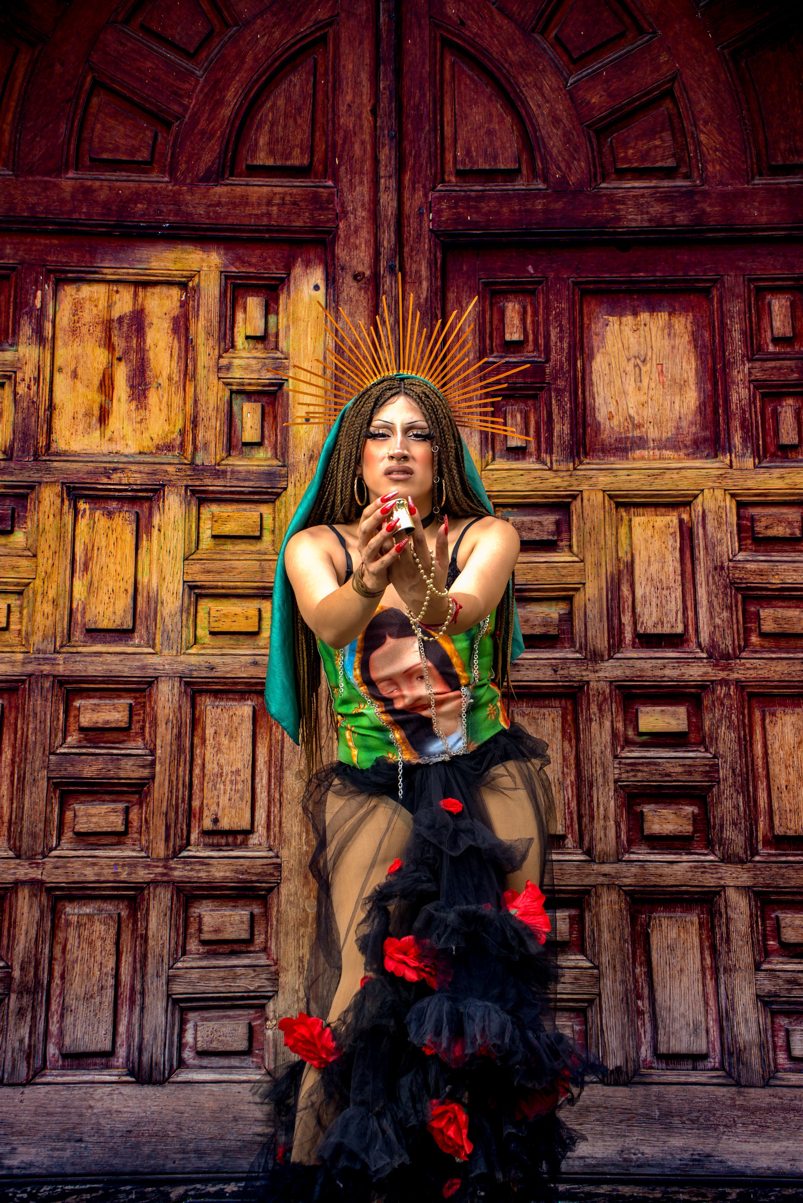 Vibrant artistic portrait of a woman in colorful attire against a wooden door.