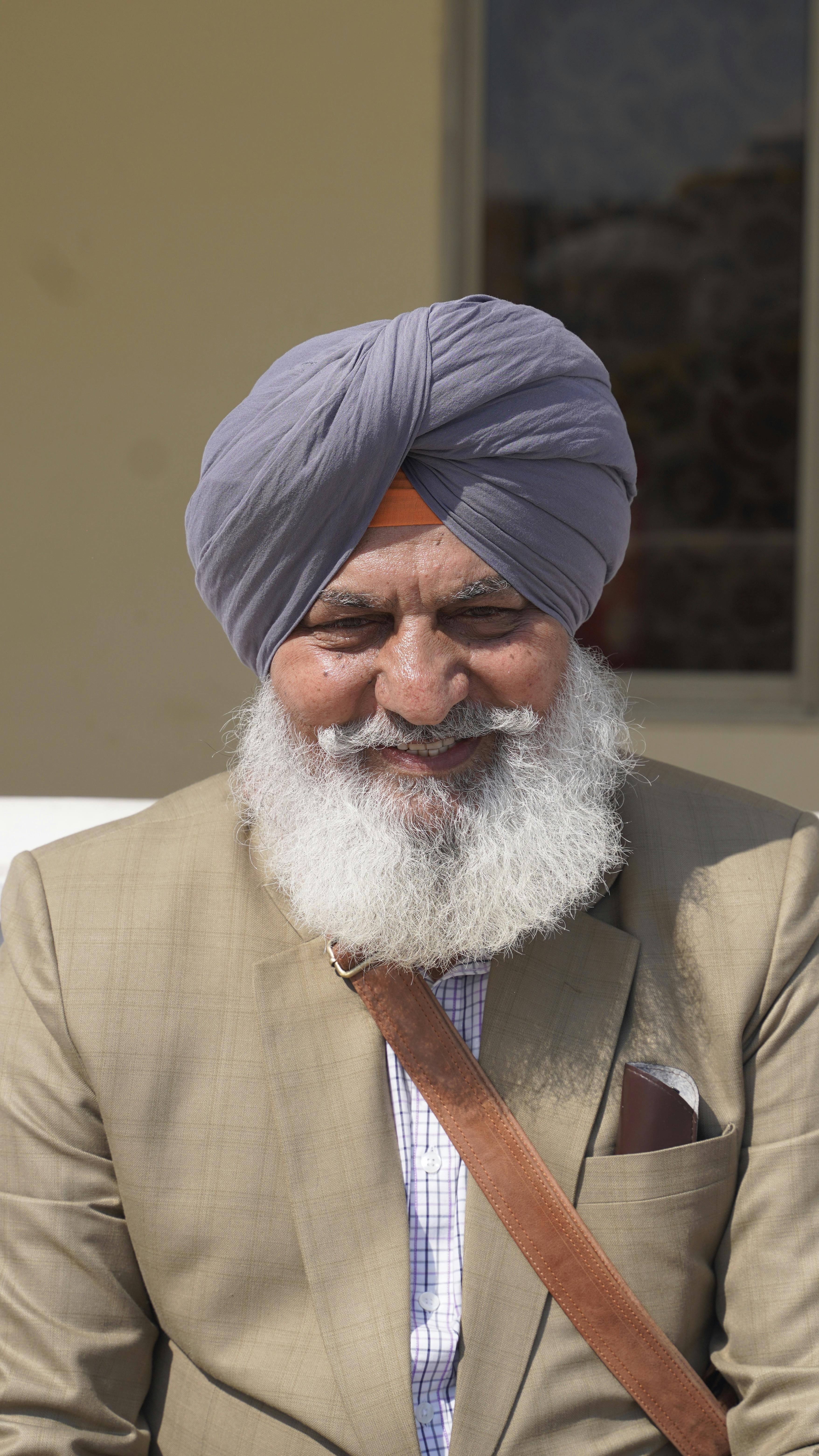 elderly man smiling in traditional turban outdoors