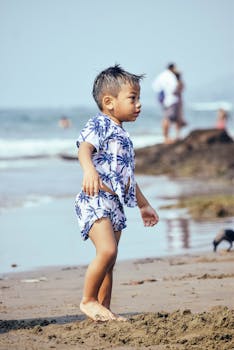 Young boy enjoying a sunny day on the beach at Vagator, Goa, India. Perfect summer vacation scene.