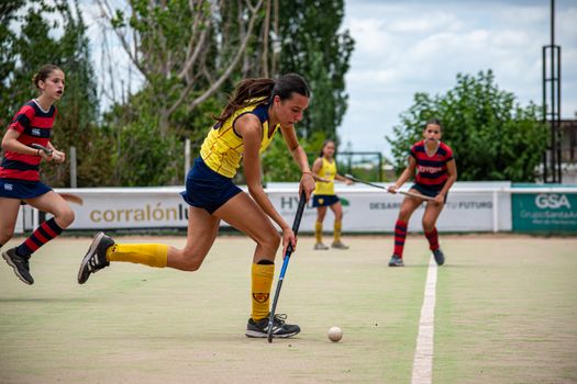 Dynamic moment from a women's field hockey game, players in motion.