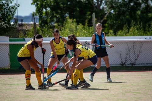 Free Young athletes competing in a dynamic field hockey game outdoors, showcasing teamwork and skill. Stock Photo