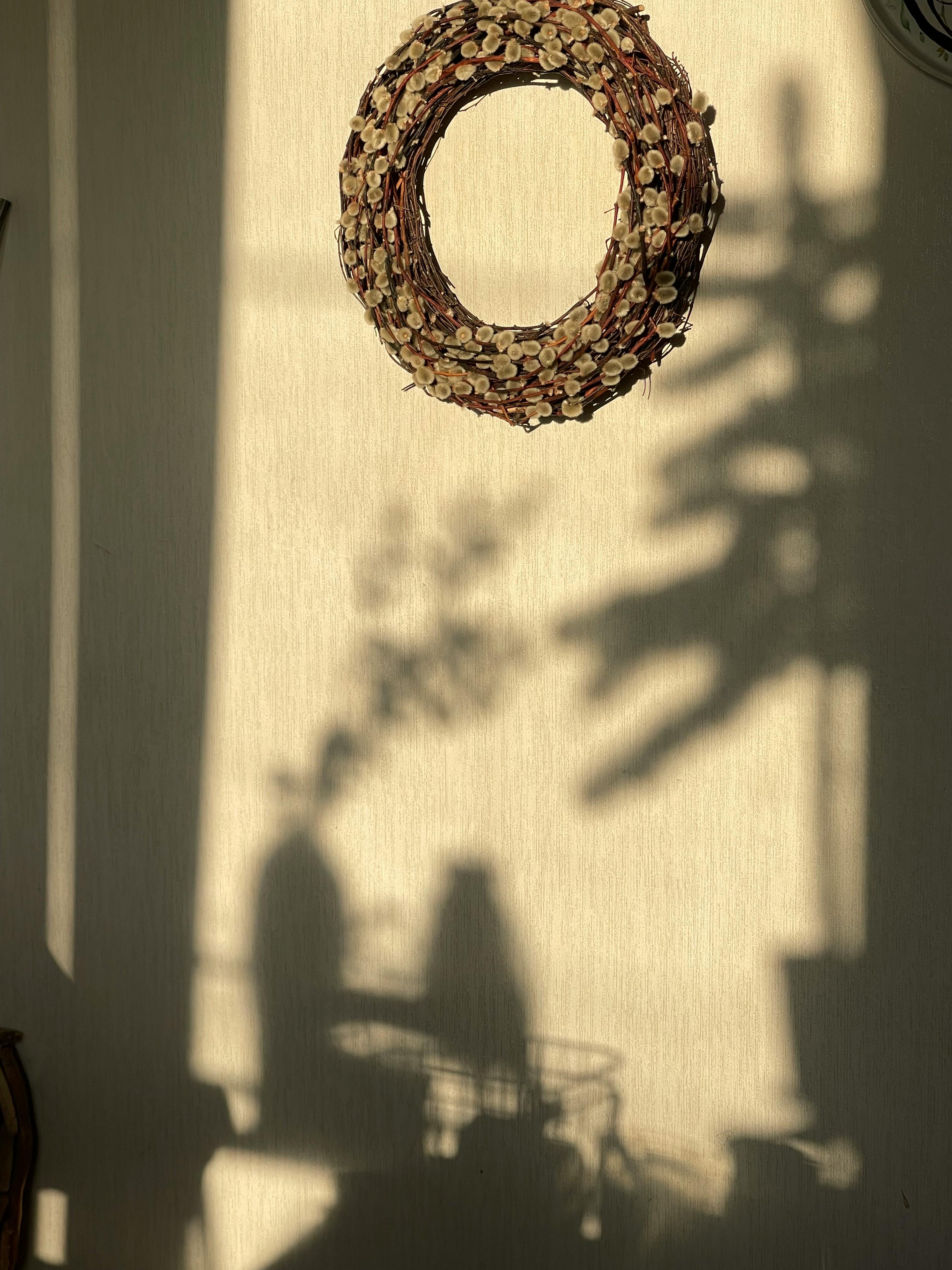 grátis Uma guirlanda decorativa projetando uma sombra criativa em uma parede com luz solar quente. Foto profissional