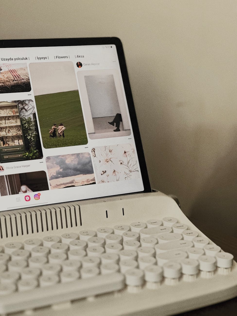 A vintage-style keyboard setup with a tablet displaying social media images, creating a cozy workspace atmosphere.