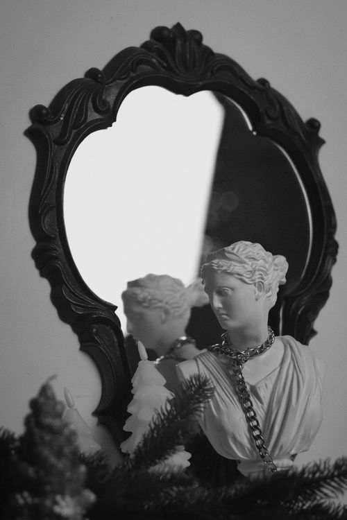 Free Black and white image of a classic sculpture reflected in an ornate vintage mirror. Stock Photo