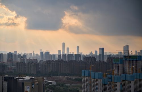 Free City skyline silhouetted against the sunset with dramatic clouds and sunrays breaking through. Stock Photo