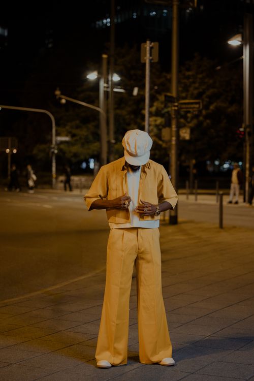 Free A person wearing stylish yellow outfit in urban street at night. Stock Photo