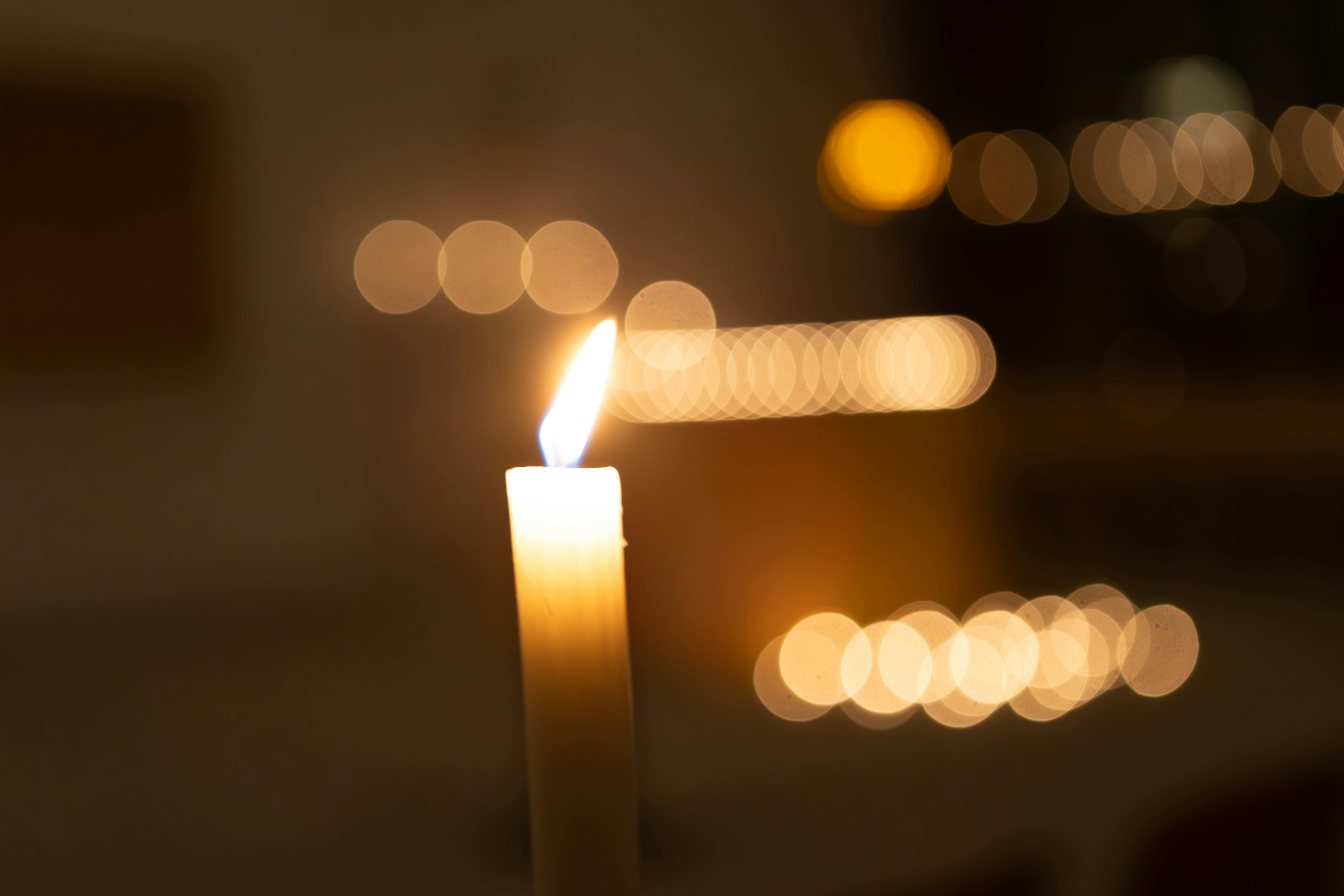 burning candle against defocused light bokeh