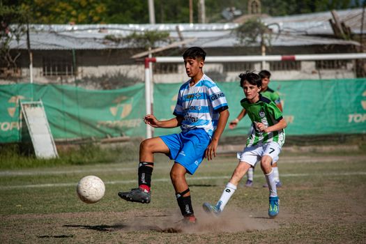 Boys playing soccer in an outdoor field, showcasing team spirit and competition.