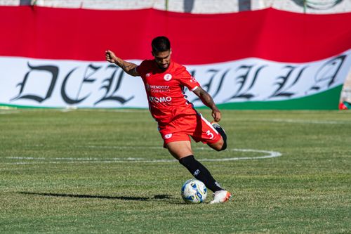 Free Action-packed moment of a soccer player in red during a competitive match on a green field. Stock Photo
