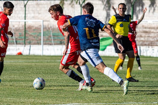 Exciting soccer match capturing competitive play between players in red and blue jerseys.