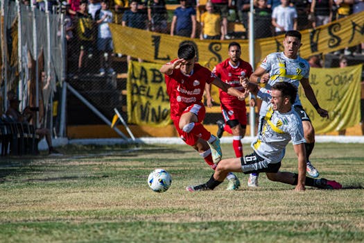 Exciting moment from a soccer match with players in action on a sunny day.