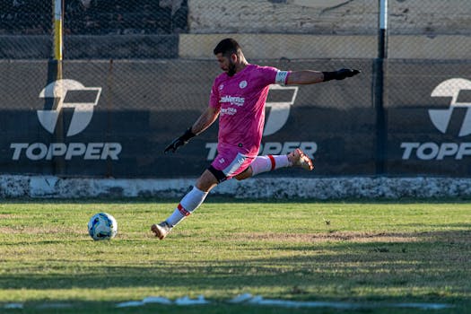 Dynamic shot of a soccer player kicking a ball on the field during a match.