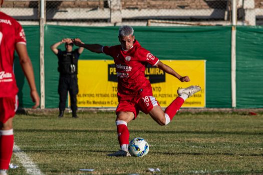 Dynamic action shot of a soccer player kicking the ball during a match.