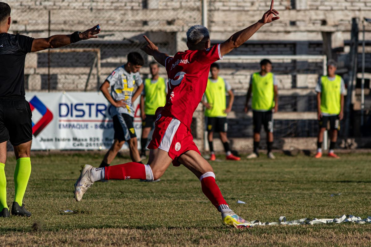 Futbol sahasında şut atan oyuncu ve kale