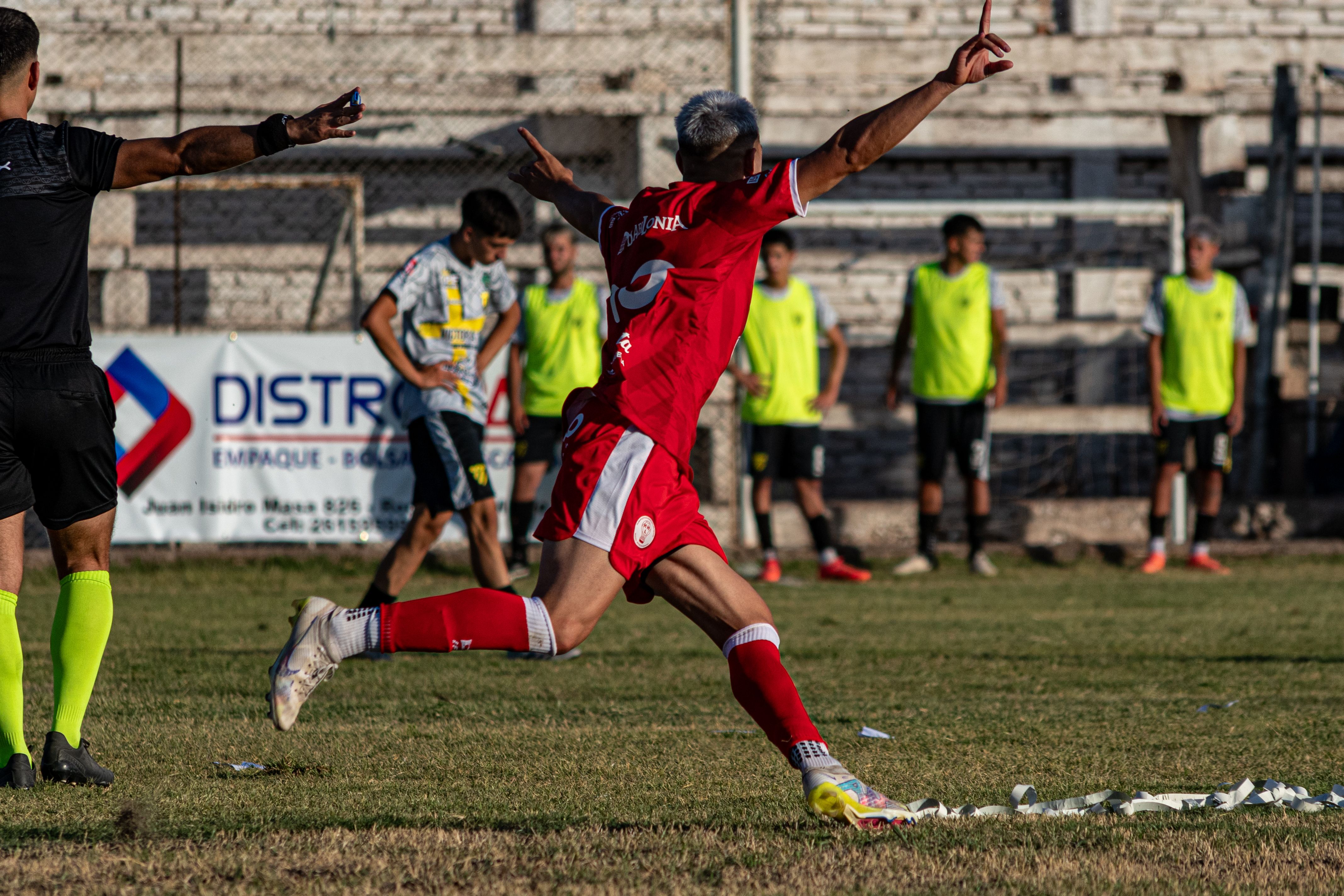 A soccer player in red celebrating a goal