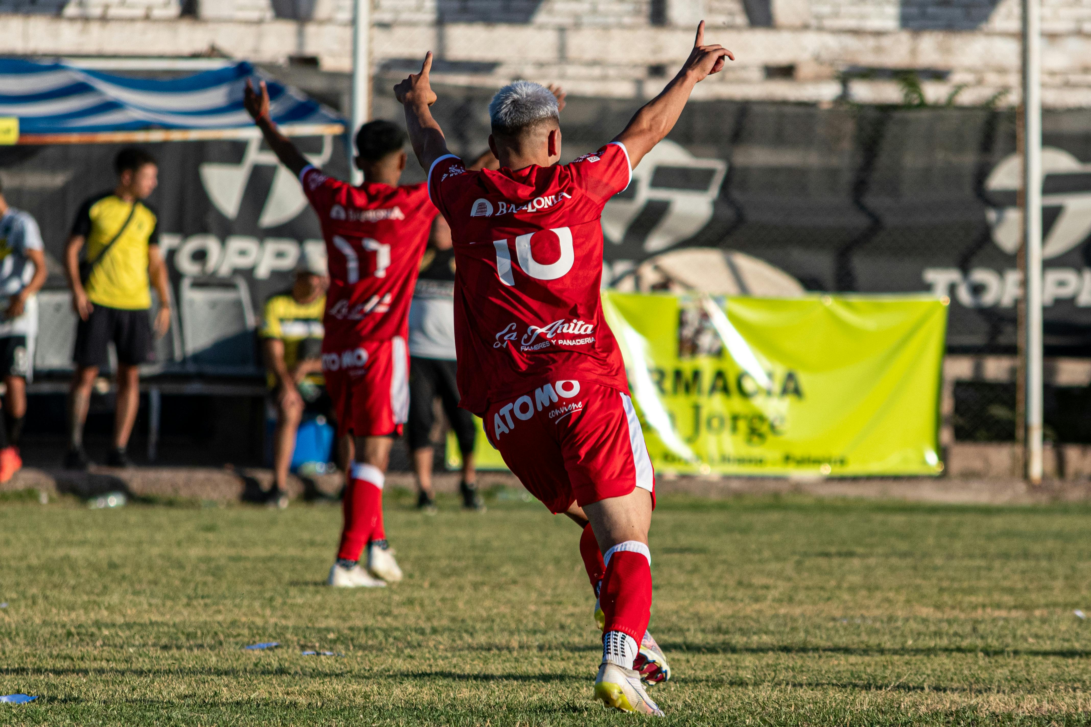 Excited soccer player celebrating a successful goal in an outdoor match.