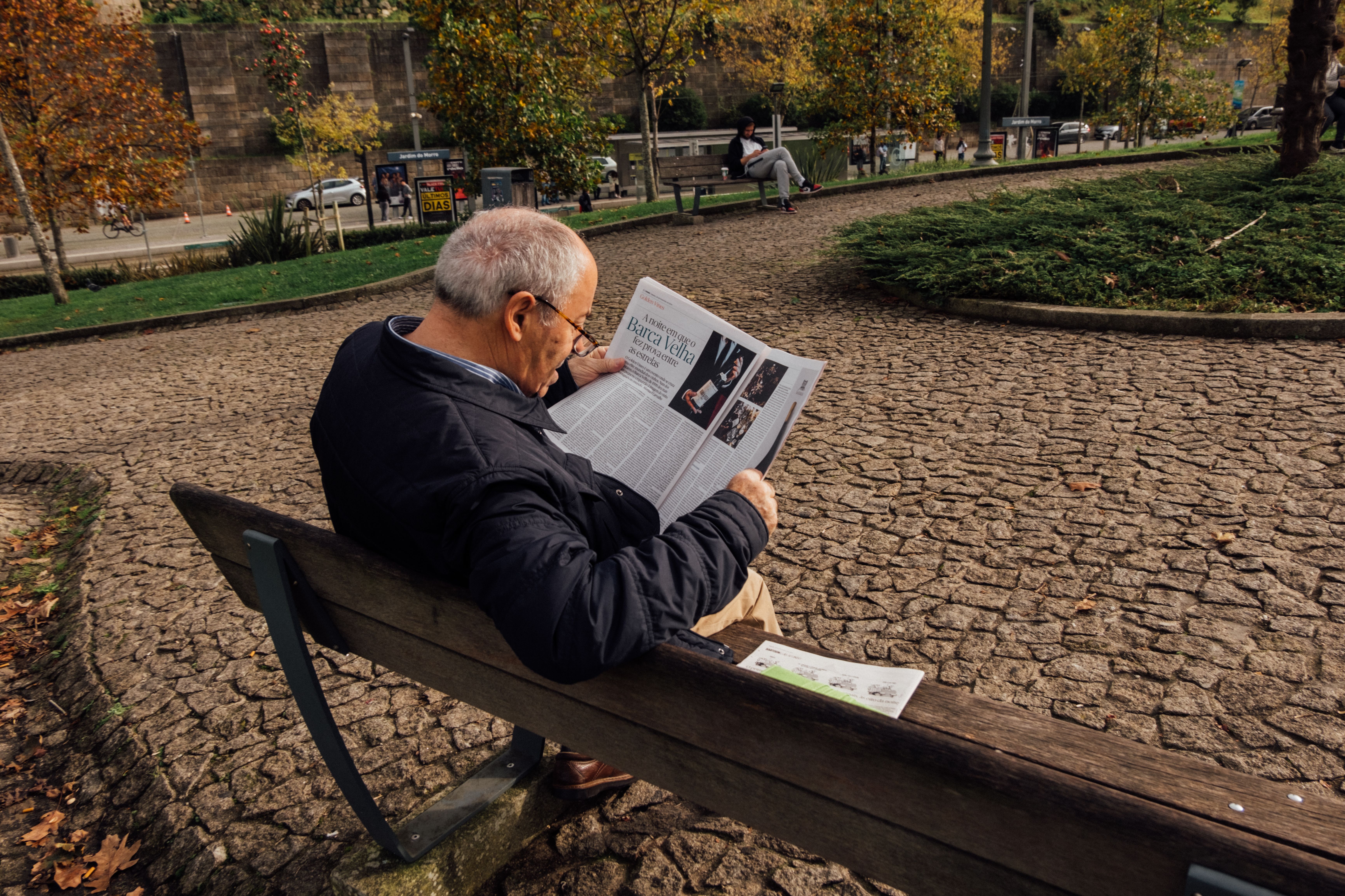 Elderly Man Reading Newspaper on Bench in Autumn Park · Free Stock Photo