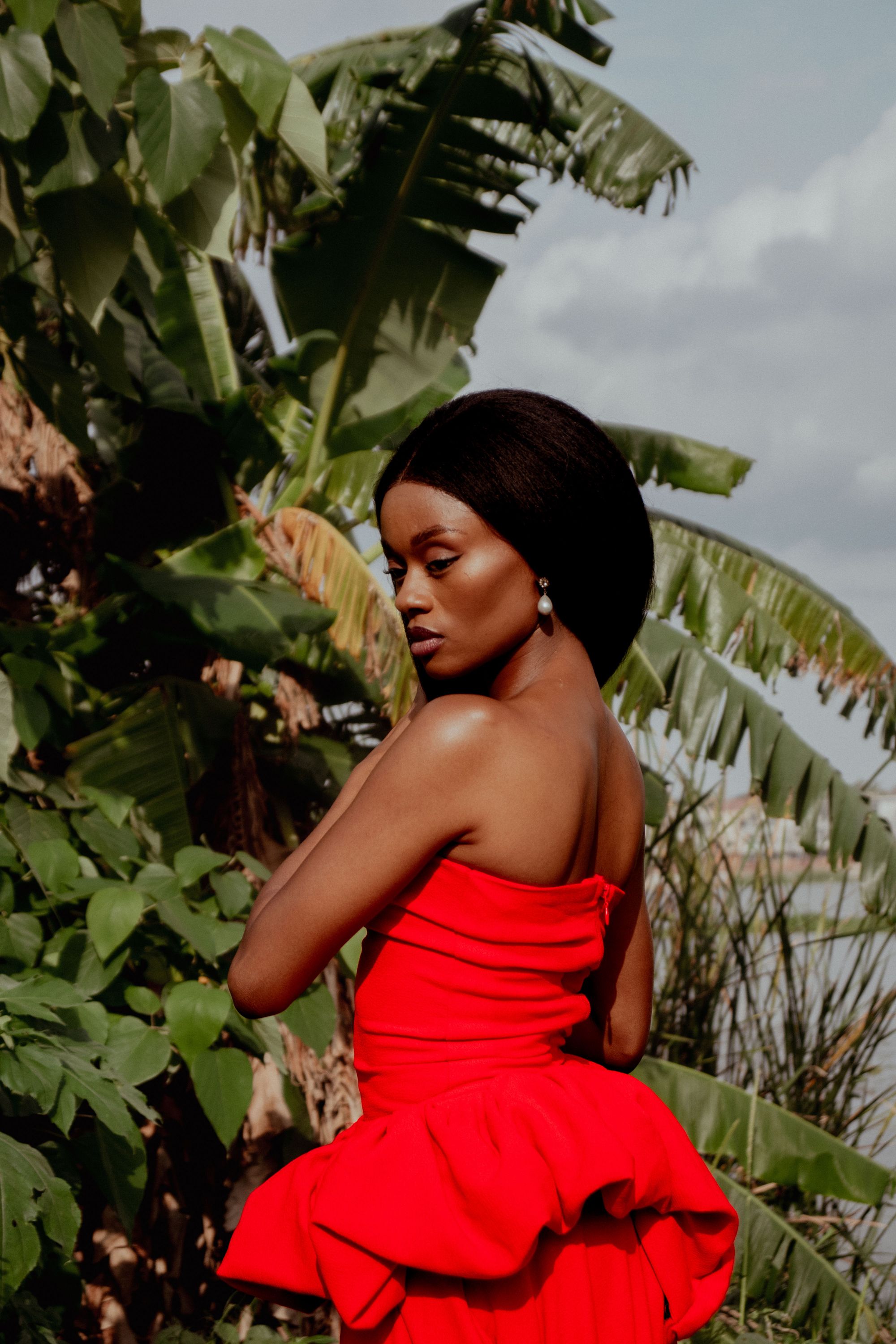 Elegant Woman in Red Dress Among Lush Greenery · Free Stock Photo