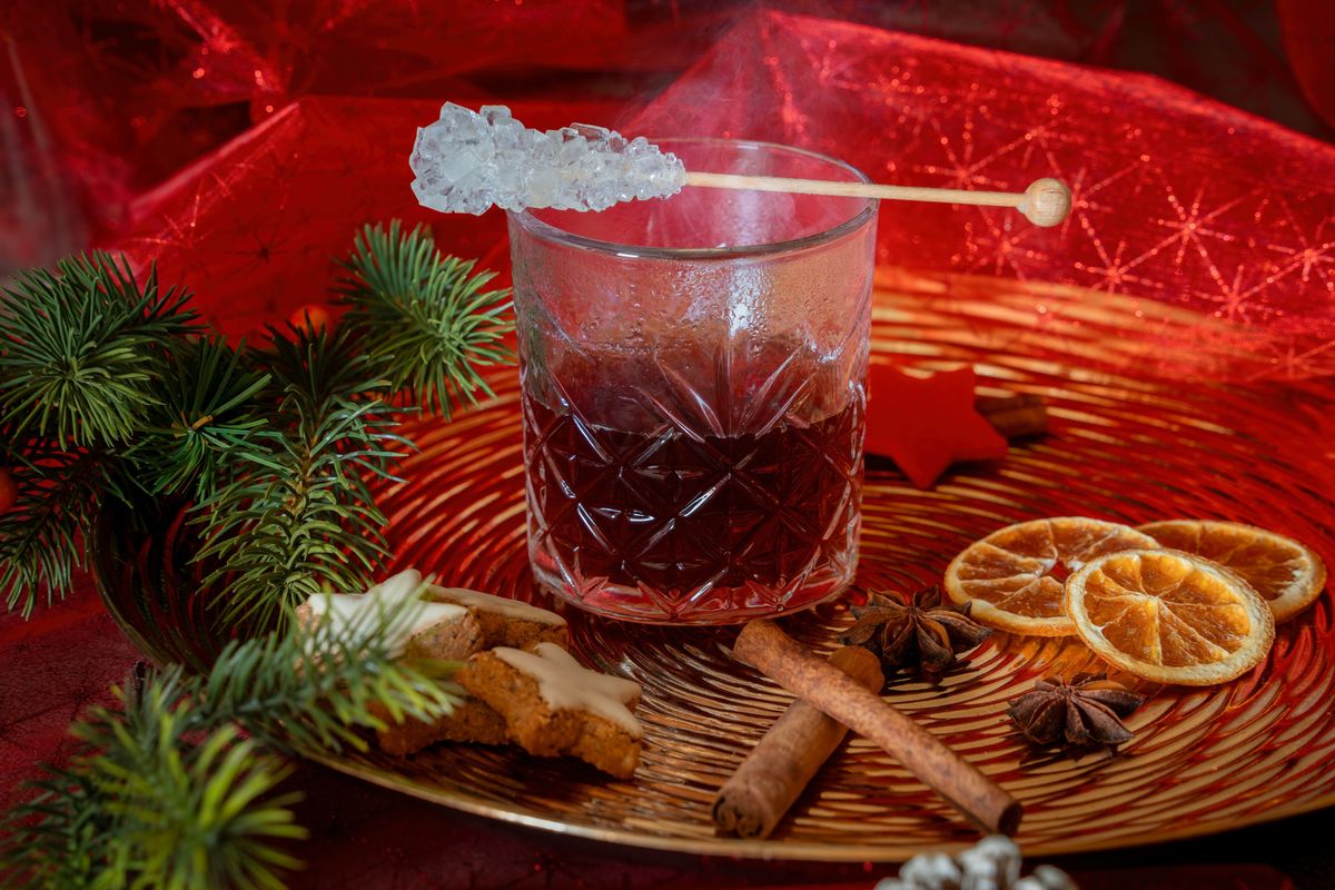 Warm holiday drink with cinnamon citrus and festive cookies