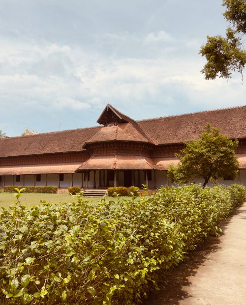 Free Serene traditional building surrounded by lush greenery and clear skies. Stock Photo