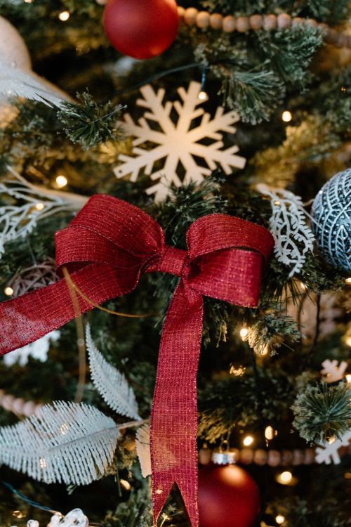 Free Close-up of Christmas tree decorated with a red bow and snowflakes. Stock Photo