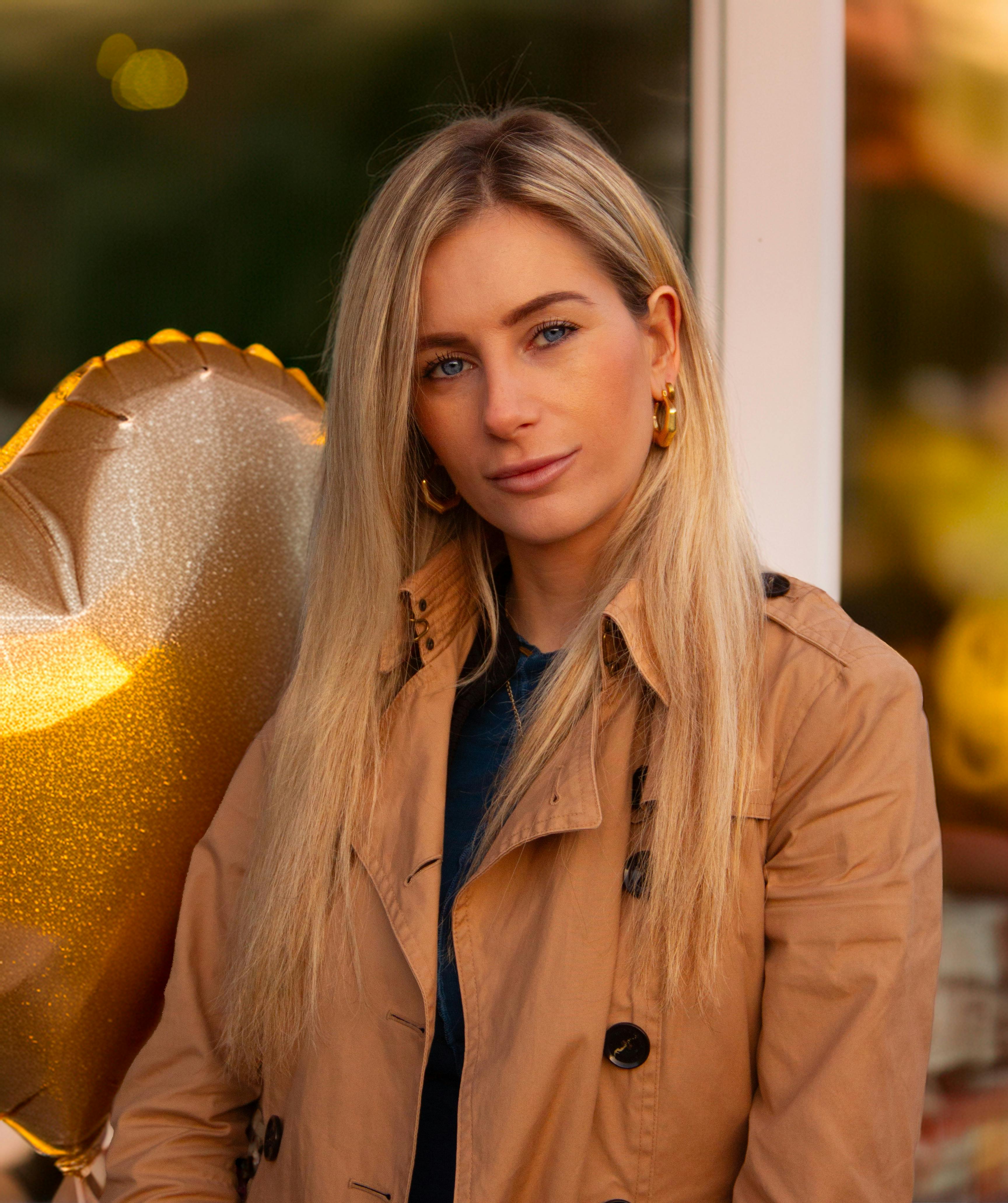 blonde woman with gold heart balloon outdoors