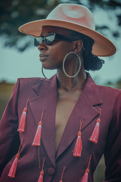 Free Elegant woman wearing a unique jacket and hat, showcasing modern fashion outdoors. Stock Photo