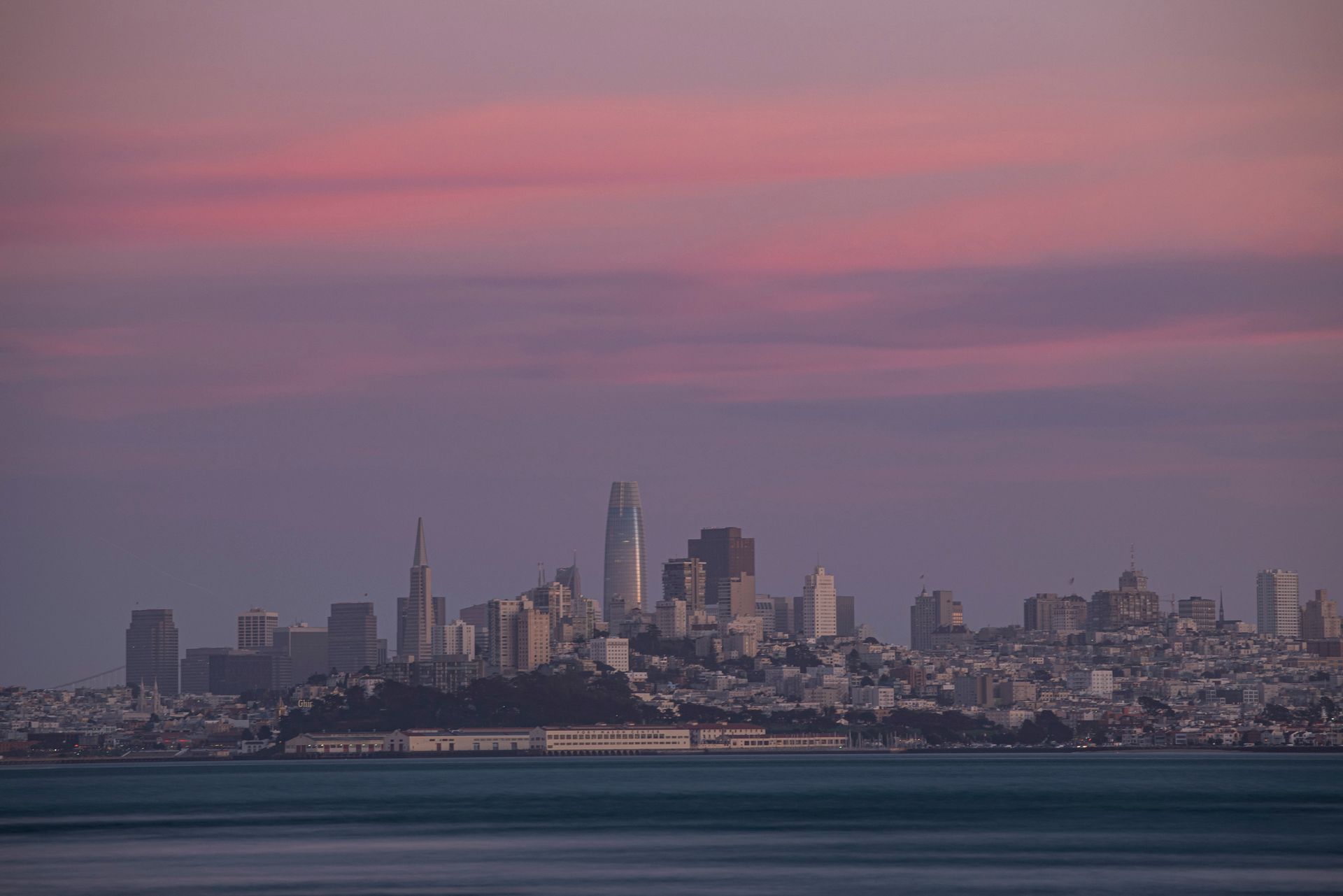 San Francisco skyline at dusk with Transamerica Pyramid and Bay Bridge visible across the water