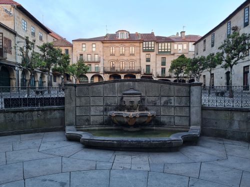 Free Charming old European square with a central fountain and historic buildings. Stock Photo