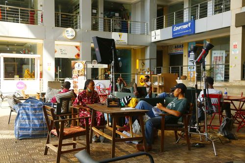 Free People relaxing in a seating area inside a bustling Abuja mall with various shops. Stock Photo
