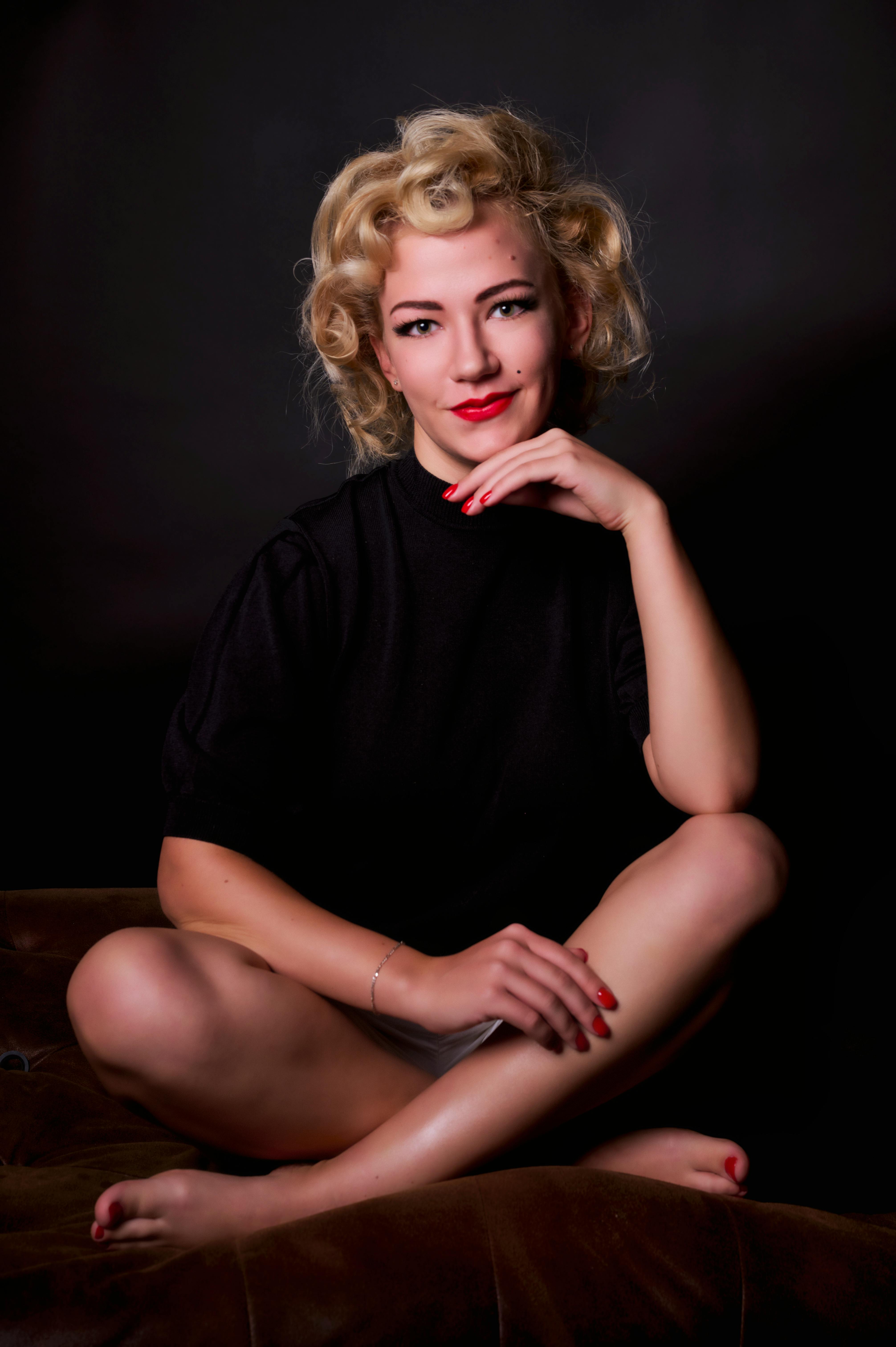Chic portrait of a woman with vintage curls and red lipstick, exuding elegance.