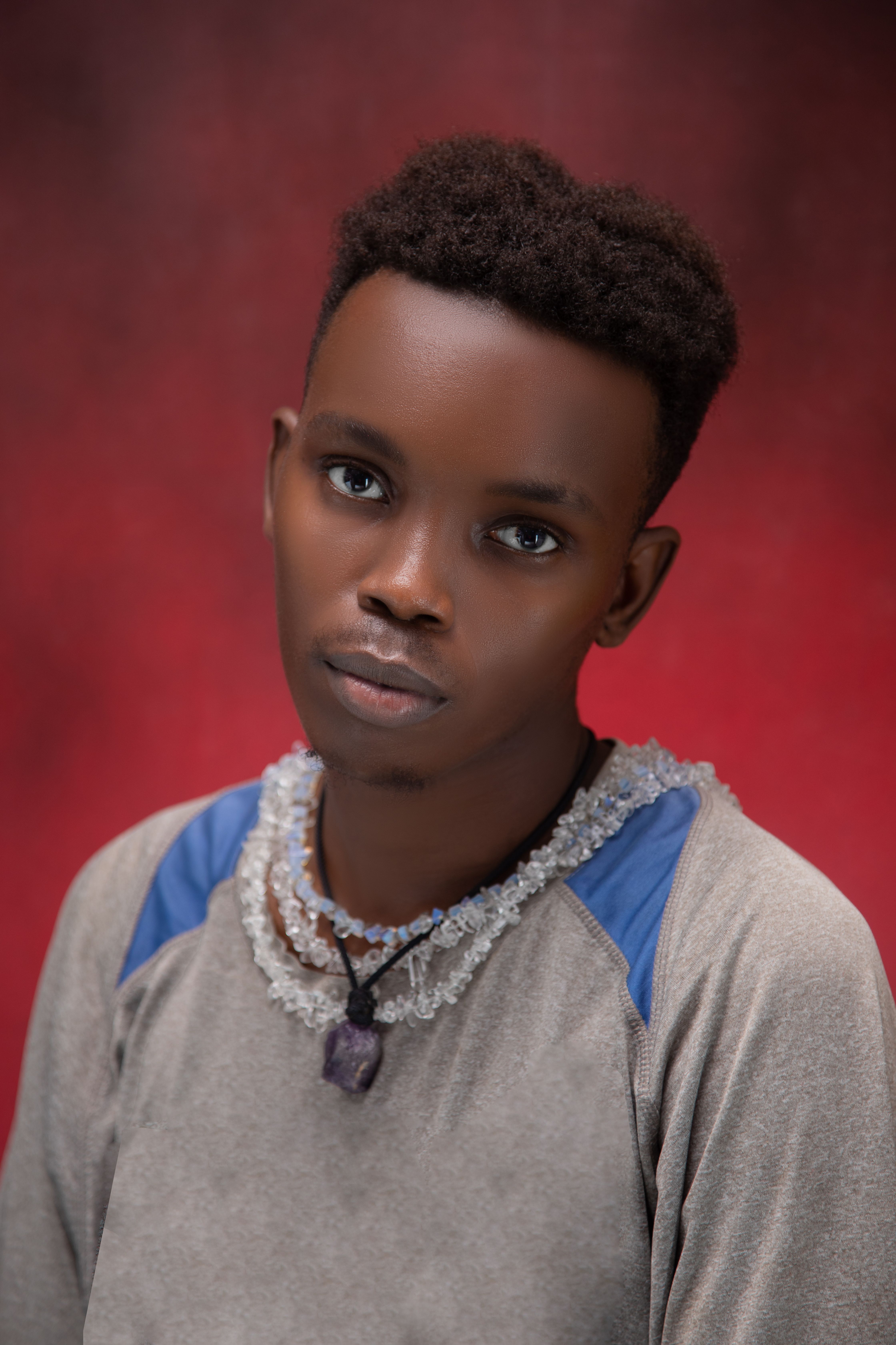 Close-up portrait of a young adult against a striking red background, exuding calm and introspection.