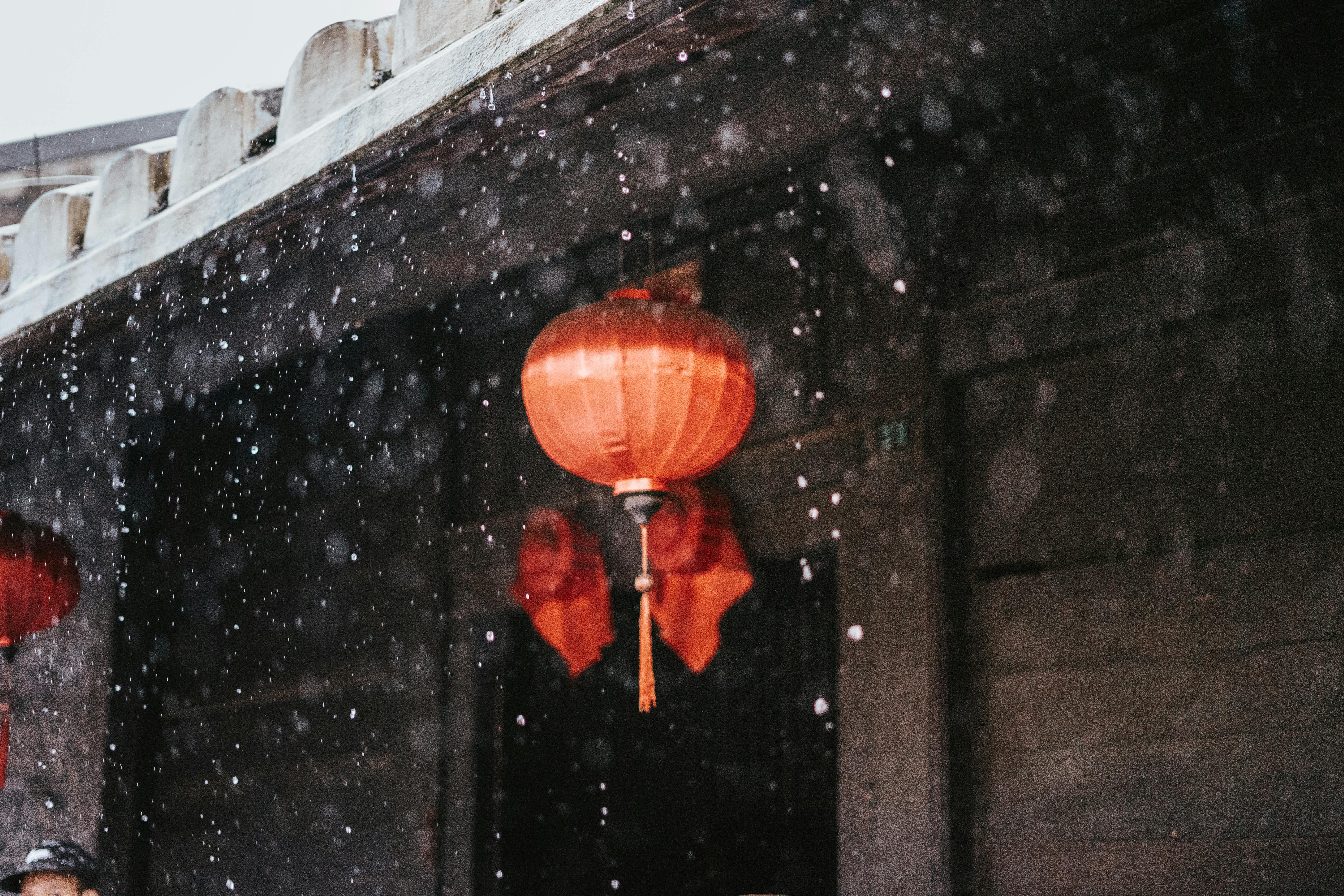 Red lanterns in Hội An, Vietnam with raindrops creating a serene atmosphere.