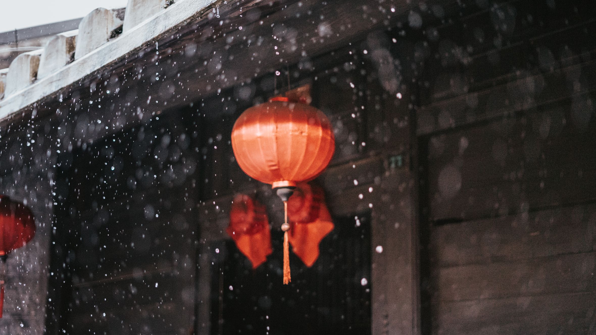 Red lanterns in Hội An, Vietnam with raindrops creating a serene atmosphere.