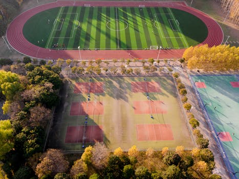 Aerial photograph of a football and tennis court in Nanjing, China during autumn.