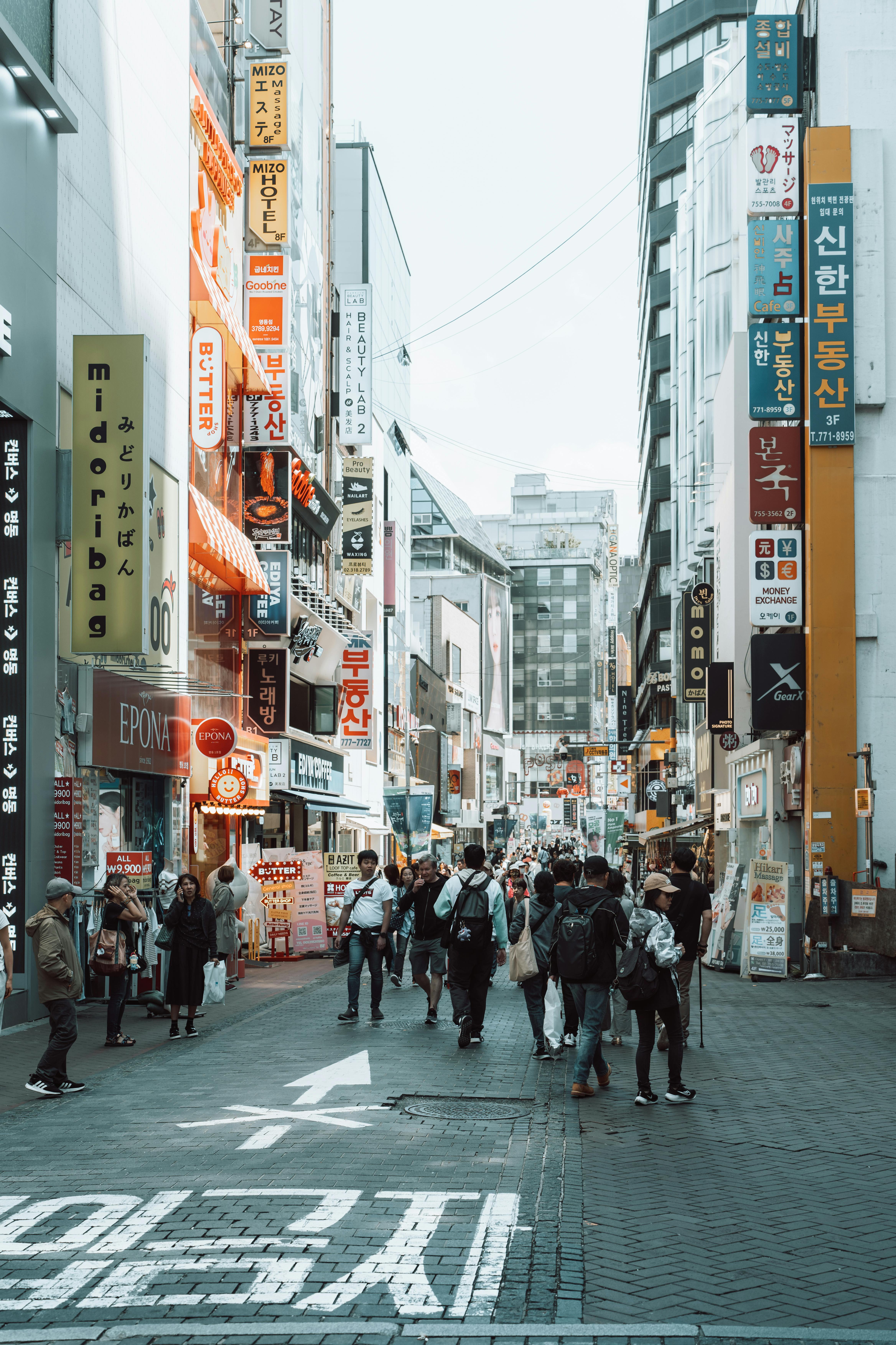 Lively street view with people and neon signs in Seoul, South Korea, showcasing urban life.