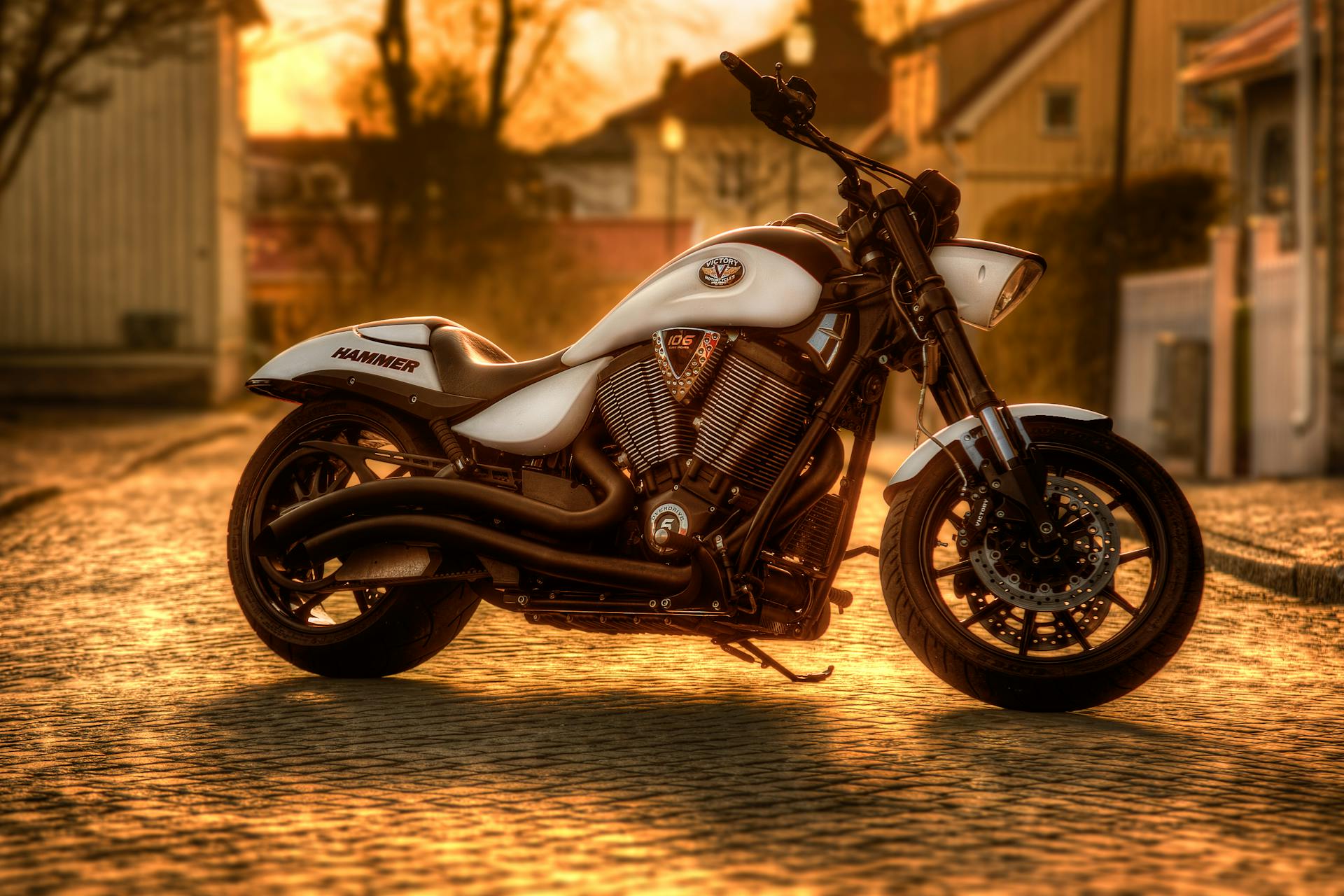 Majestic motorcycle bathed in warm sunset light on a cobbled street in Norra Skara, Sweden.