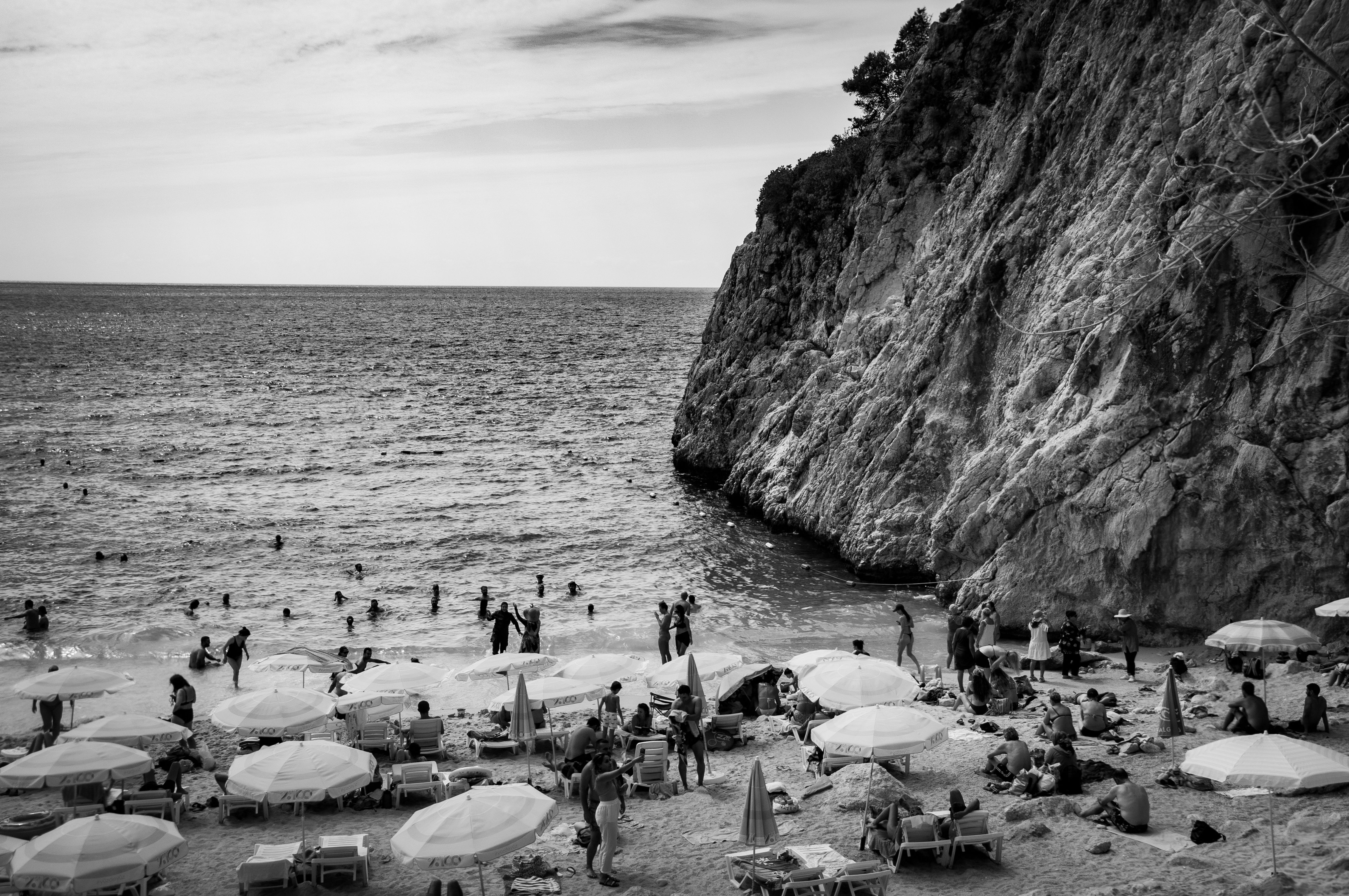 Black and White Beach Scene with Cliffs · Free Stock Photo