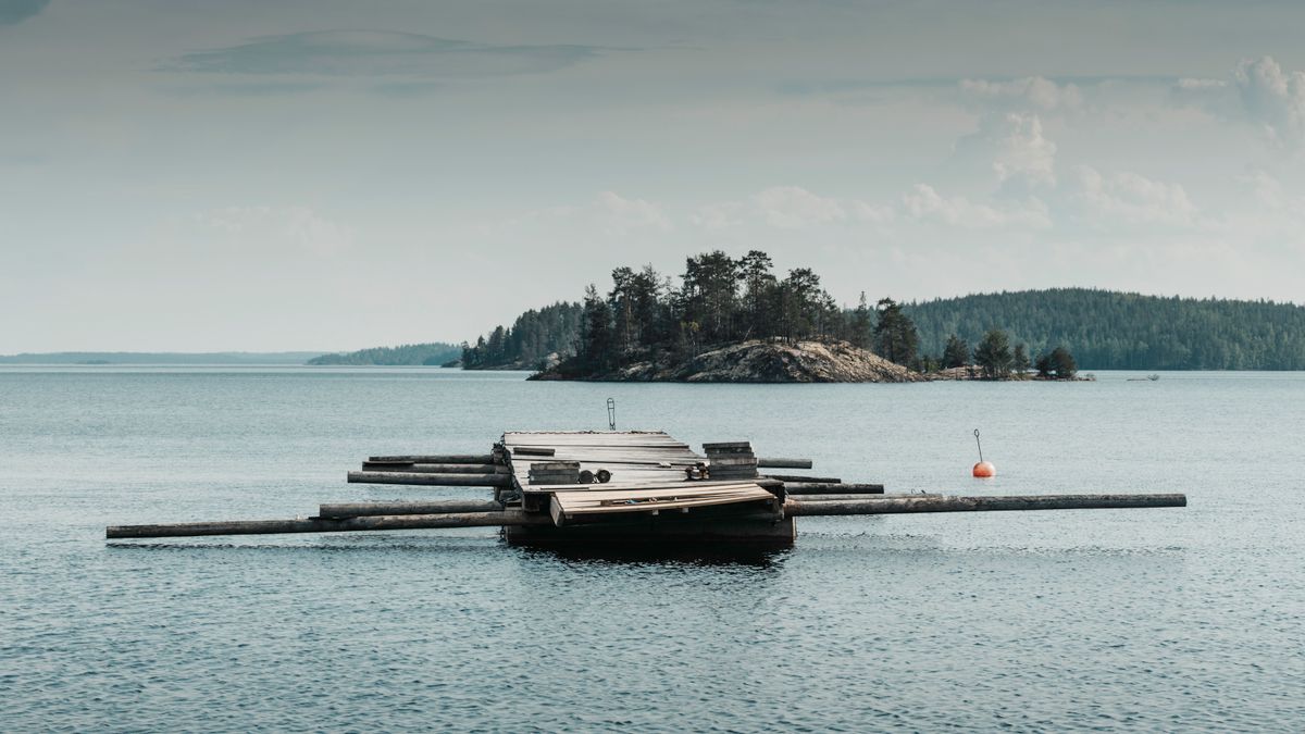 Priveliște de lac cu ponton de lemn, în Finlanda