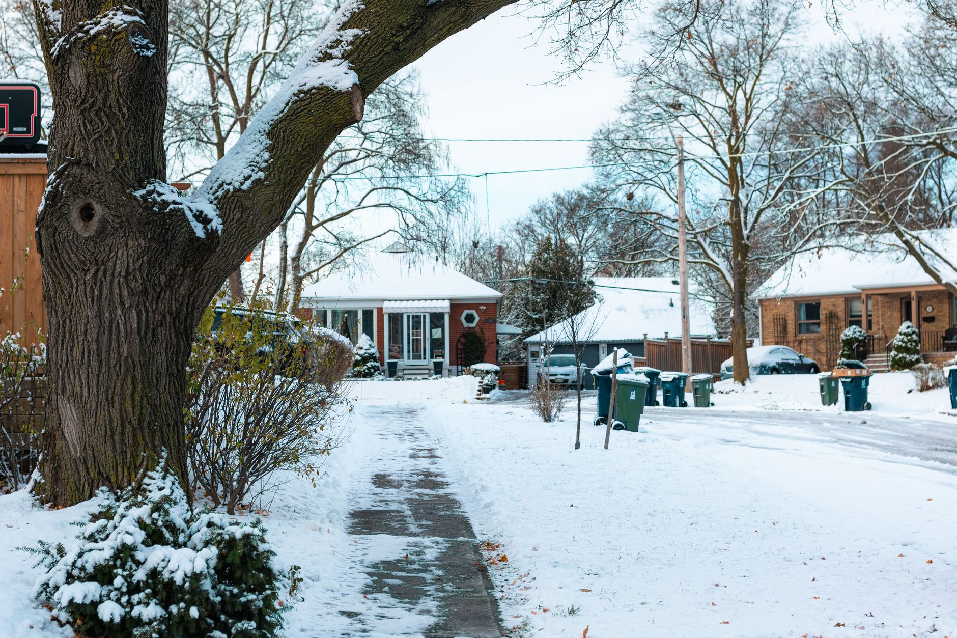 Snow-covered residential street with houses after a winter storm