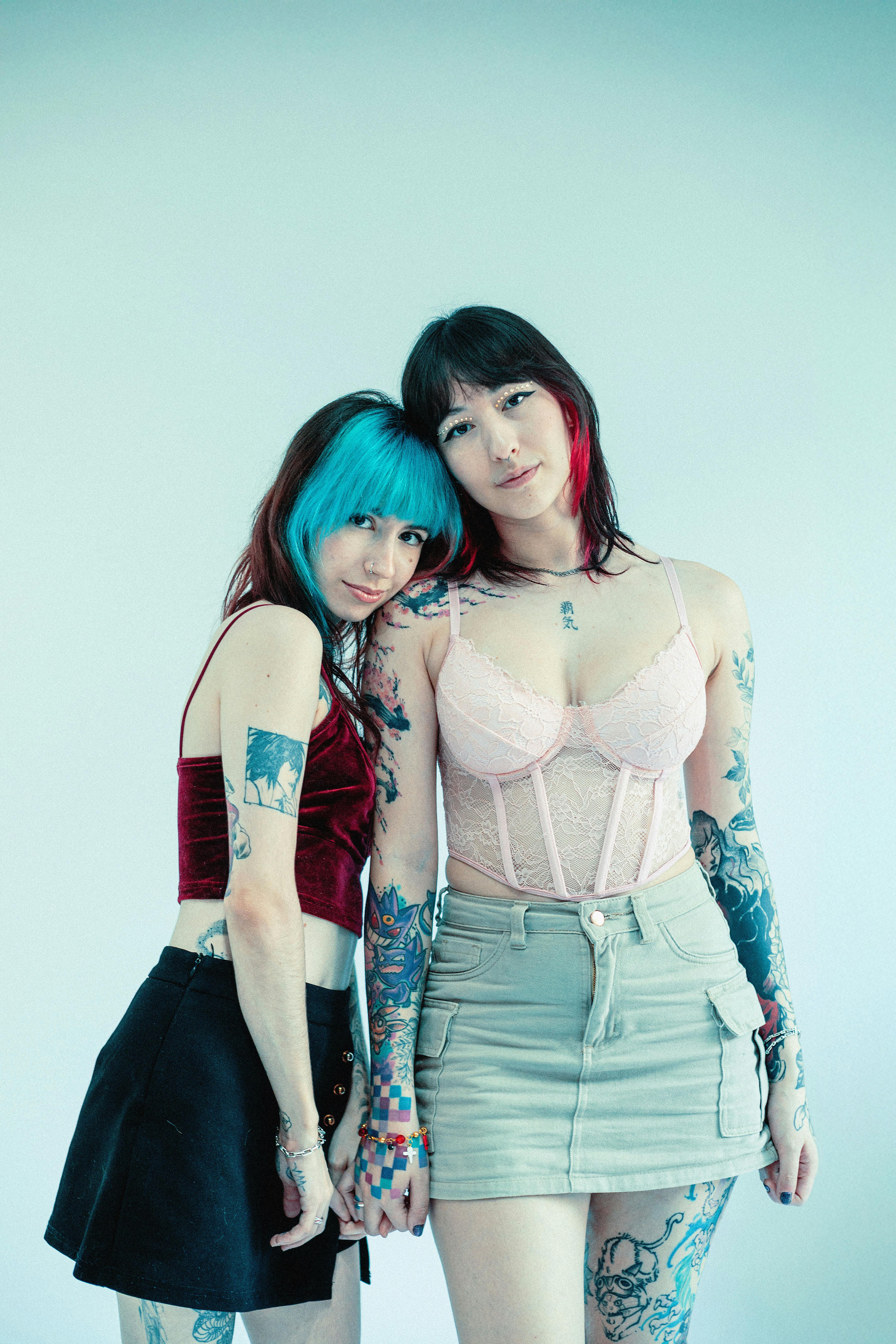 tattooed friends embrace in stylish attire