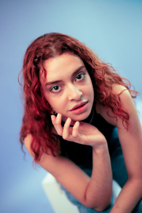 Free Vibrant portrait of a young woman with red curly hair, expressive pose, São Paulo. Stock Photo