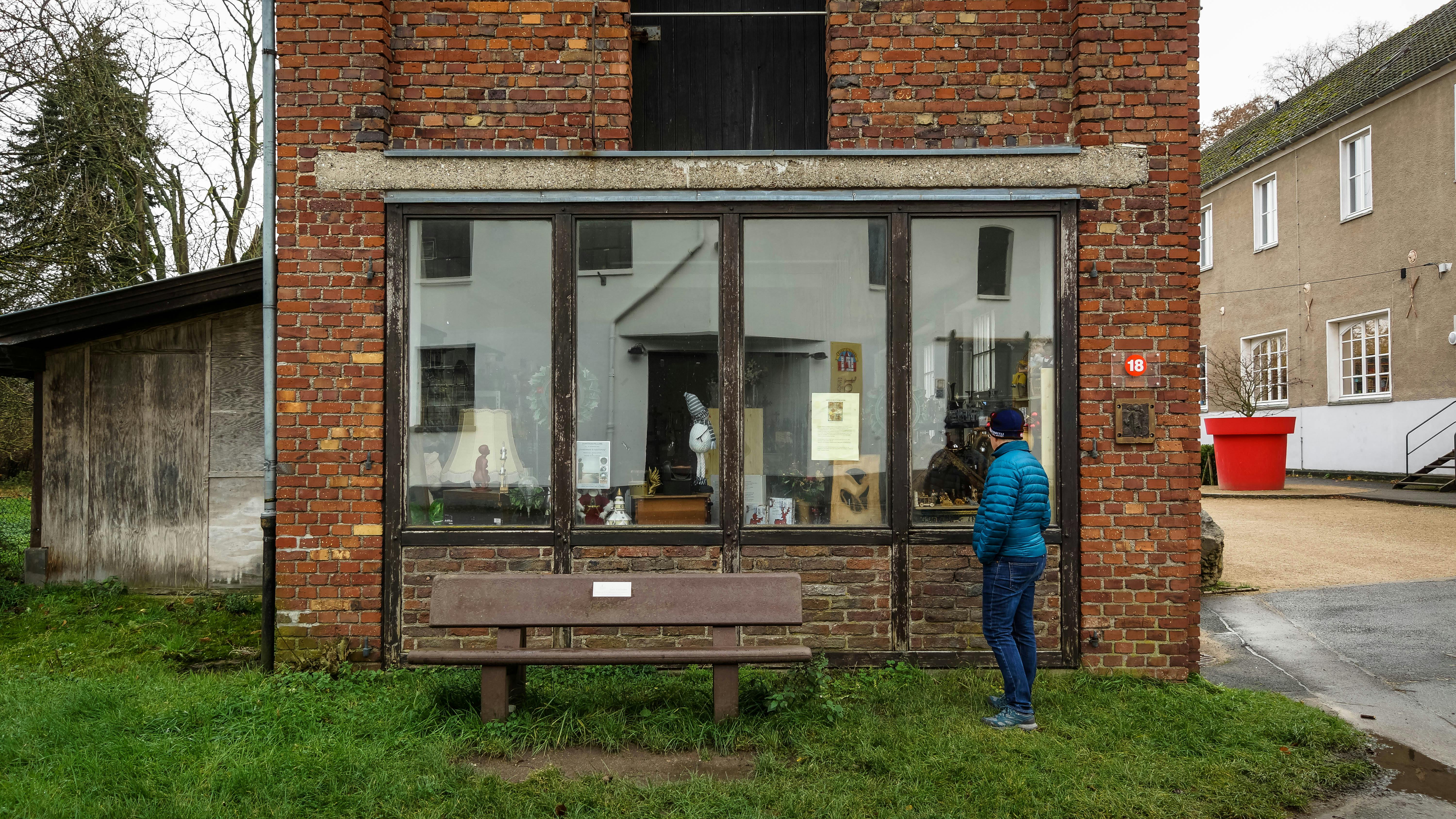 man observing rustic brick building window display