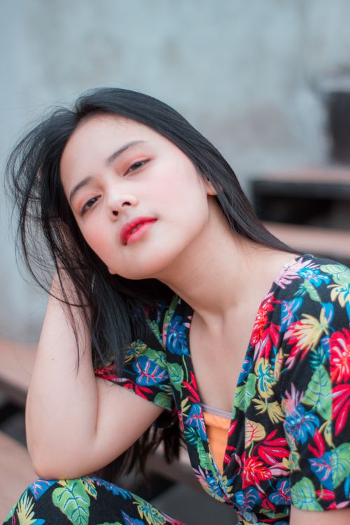 Free Vibrant portrait of a young woman with floral attire, outdoors during the day. Stock Photo