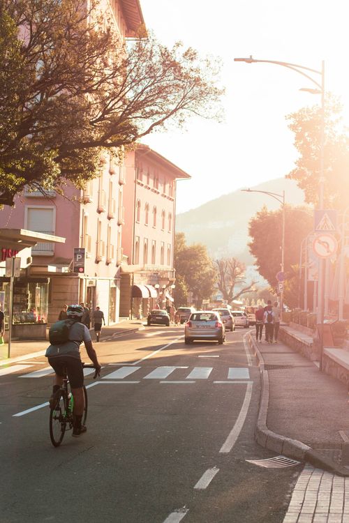 Free Cyclist on a sunlit street in Opatija, Croatia, capturing the vintage summer vibe. Stock Photo