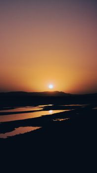 A breathtaking sunset over a serene river landscape, creating a warm and tranquil atmosphere.